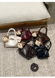 Détails de sacs seaux en cinq couleurs avec breloques d'ours et texture en cuir lisse