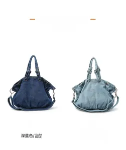 Detail view of denim tote bags in dark and light blue with metallic eyelets and strap