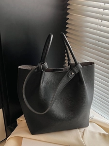 Premium black pebbled leather tote bag with dual handles and studded shoulder strap