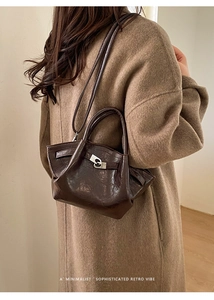 Détail du sac seau marron foncé avec texture plissée vintage et boucle argentée élégante