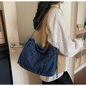 Detail of blue denim tote bag with SUBELETING embroidery and pleated stitch design