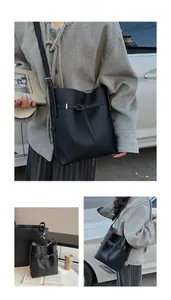 Detail of black lychee grain leather bucket bag with silver hardware and drawstring closure