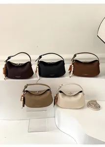 Close-up of pebble leather handbags in five colors with beaded charms and metal clasps