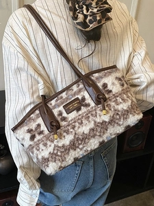 Large plush tote bag with geometric pattern and brown leather straps for commuting