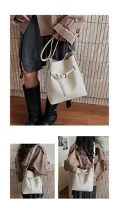 Detail of white lychee pattern leather bucket bag with adjustable strap and buckle