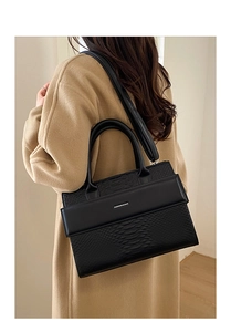 Detail of black crocodile texture tote bag with Fashion & Bag text on khaki coat