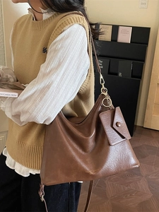 Brown large capacity hobo bag with matching small pouch in street style setting