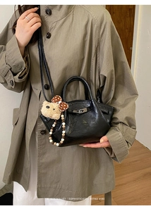 Détail du sac seau noir vintage en cuir froissé avec fermoir argenté et breloque ours