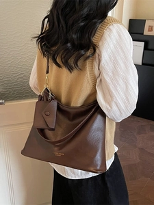 Vintage brown leather shoulder bag with matching mini pouch and stylish fashion branding