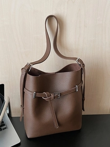 Large dark brown pebble leather bucket bag with silver buckle in office setting