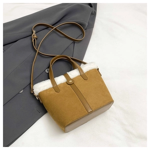 Detail of brown suede bucket bag with white faux fur trim and gold metal snap closure