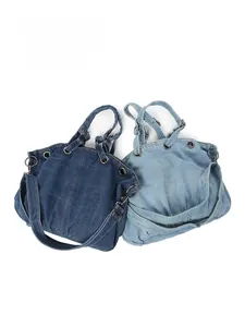 Detail view of washed denim tote bags in dark and light blue with metal eyelets