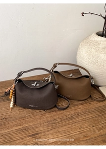 Detail of vintage textured leather handbags with metal twist locks and wooden bead charms