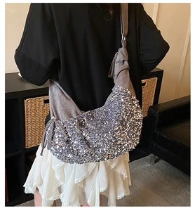 Detail of silver sequin crescent bag with drawstring and soft suede shoulder strap