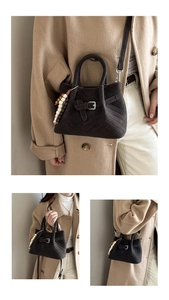 Close-up of dark brown suede handbag with V-quilted texture and colorful bead charm