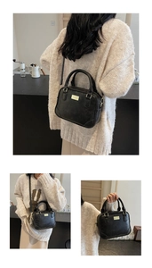 Detailed view of a vintage black leather crossbody bag with elegant gold metal hardware