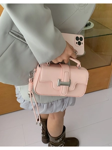 Detail of pink crossbody bag with matte metal buckle and soft synthetic leather texture