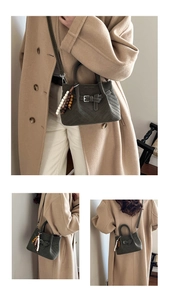Detail view of olive green matte handbag with V-quilting and wooden bead charm