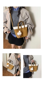 Detail view of vintage brown suede handbag with white faux fur trim and pompom charm