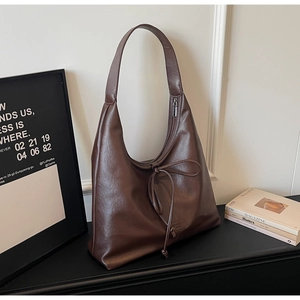 Détails du sac hobo marron vintage avec cordons de serrage et finition en cuir mat