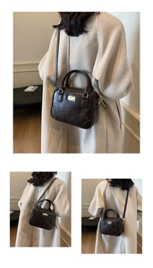Close-up of vintage brown oil-wax leather Boston bag with metallic logo and dual handles