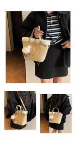 Detailed view of beige handbag featuring white faux fur trim and plush ball charm accessory