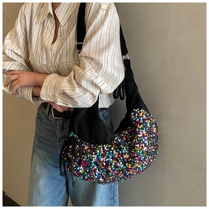 Detail of colorful sequins on black canvas bag with adjustable wide shoulder strap