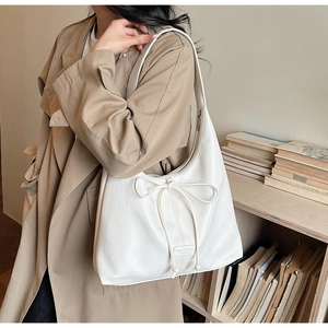 Détail du sac fourre-tout blanc crème avec cordon nœud et logo en cuir sur similicuir souple