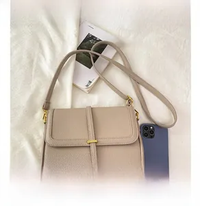 Sac à bandoulière en cuir grainé avec comparaison de taille par rapport à un smartphone