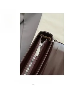 Detail view of smooth chocolate brown leather with shiny silver metal zipper and inner lining