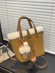 Brown suede bucket bag with white faux fur trim and adjustable crossbody strap