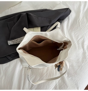 Interior of white leather tote bag showing brown lining and multiple storage pockets