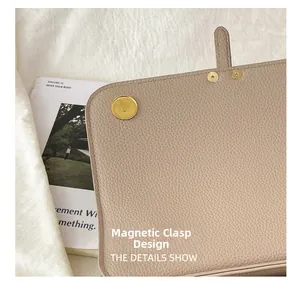 Détail du sac à main en cuir beige à motif litchi avec fermoir magnétique doré