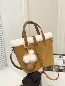 Brown suede tote bag with white faux fur trim and plush glove charm shown in hand