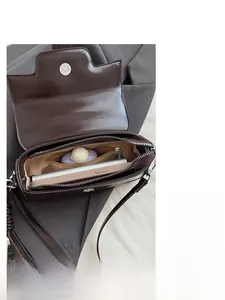 Detailed interior of vintage brown patent leather handbag with multiple compartments