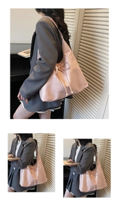 Pink large capacity hobo bag featuring a decorative bow on an Asian model in a gray suit