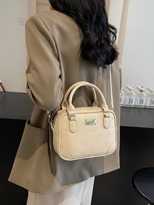 Elegant beige vintage leather bowling bag with gold hardware and shoulder strap