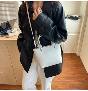 Detailed view of a white leather bucket bag with knotted handle in an urban office setting