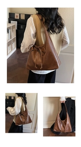 Close-up of brown retro leather tote bag featuring bow drawstring detail and textured finish