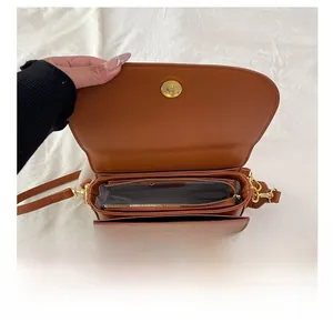 Détails du compartiment intérieur multicouche et du rabat magnétique du sac selle en cuir brun