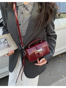 Close-up of a burgundy leather small square bag with silver H-buckle and top handle