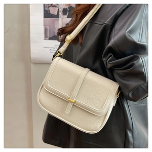Gros plan du sac à bandoulière en cuir grainé crème avec boucle en métal doré