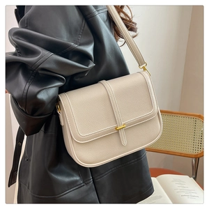 Détail du sac à bandoulière en cuir blanc cassé avec boucle en métal doré