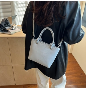 Detail of grey-blue leather bucket bag with unique knotted handles and MIAOSHE BAGS logo