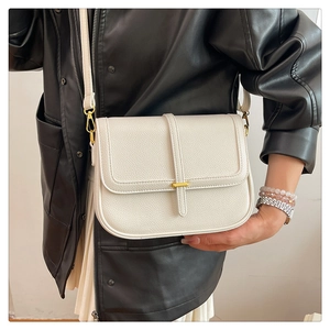 Détail du sac bandoulière blanc en cuir grainé avec boucle en métal doré élégante