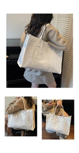 Detail of white tote bag featuring clear PVC overlay with wrinkled texture and embossed text