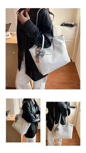 Close-up of white PU leather tote bag texture with cute plush bear charm and long strap