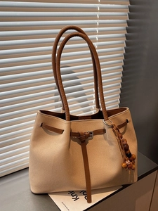 Vintage canvas tote bag with brown leather straps and decorative bead pendant
