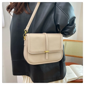 Détail du sac bandoulière en cuir grainé beige avec boucle métallique dorée élégante