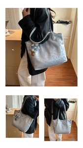 Detail view of silver PU leather tote bag with vintage texture and cute bear pendant